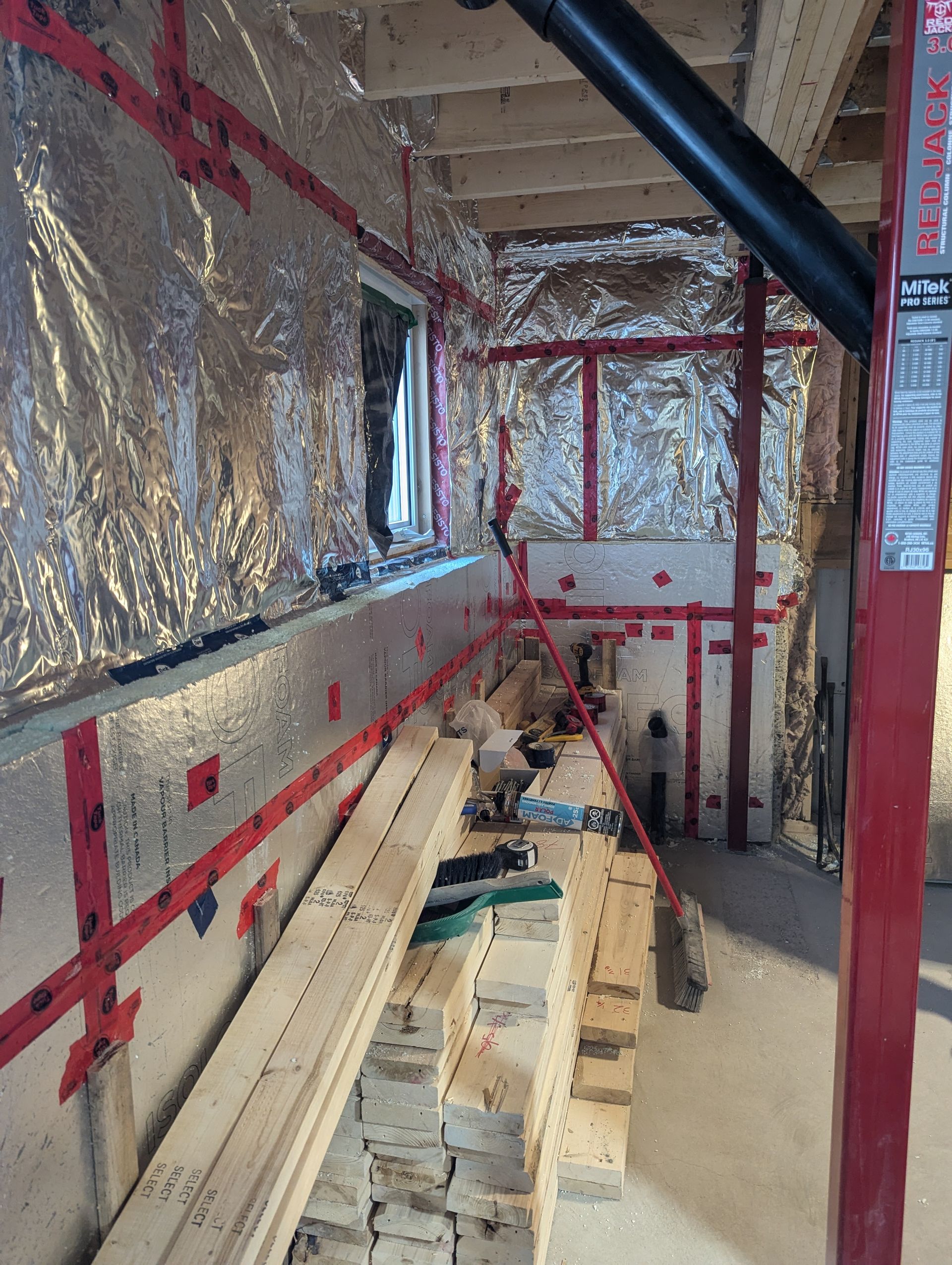 Une pièce avec beaucoup de bois et de papier aluminium sur les murs.