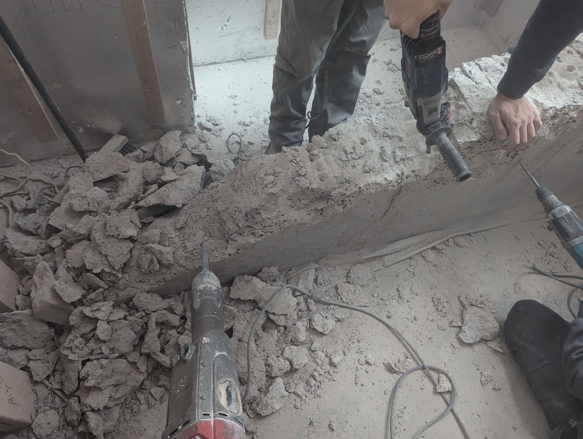 Un homme utilise un marteau pour percer un trou dans un mur.