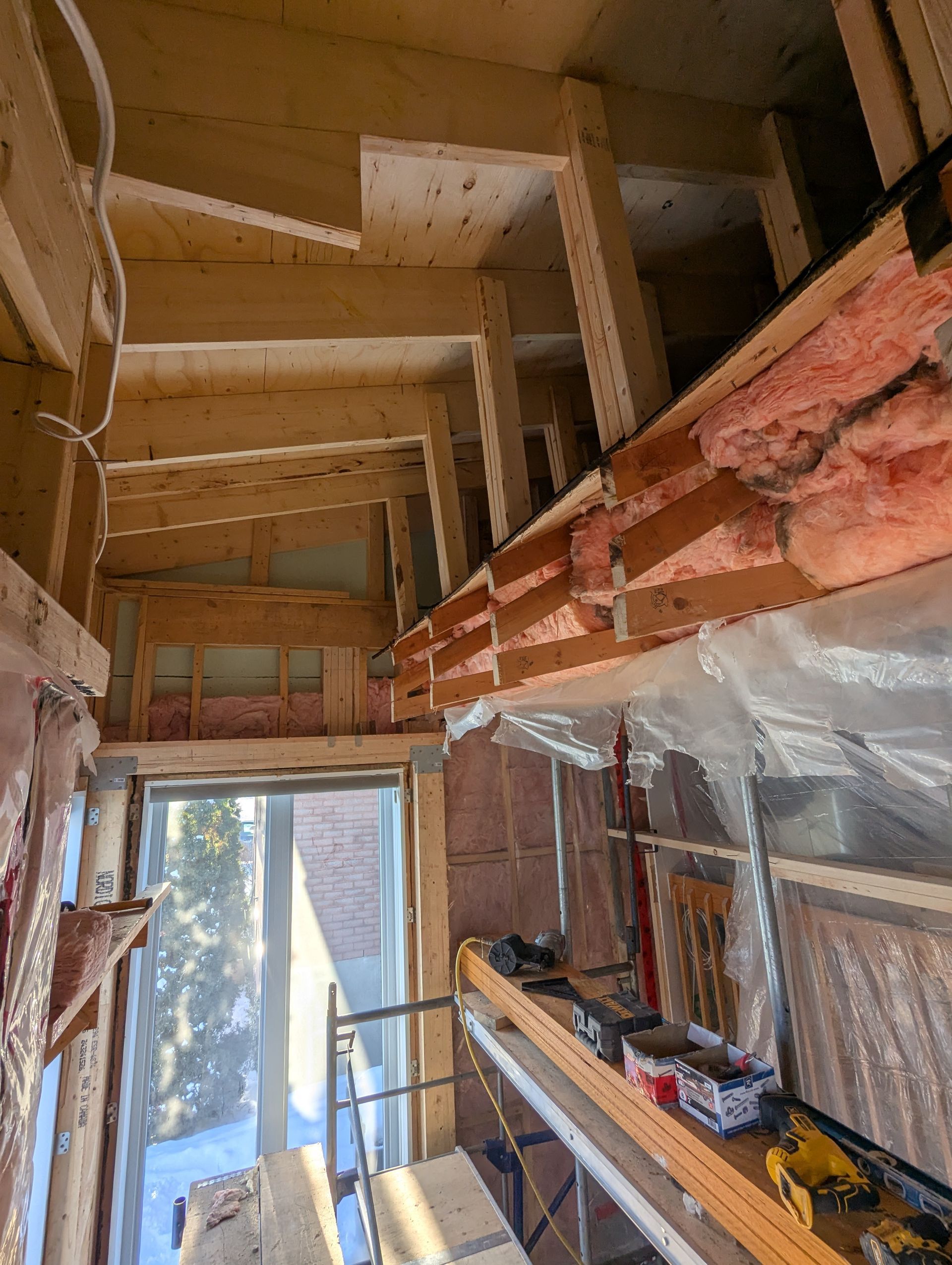 Une pièce avec beaucoup de poutres en bois et une fenêtre.
