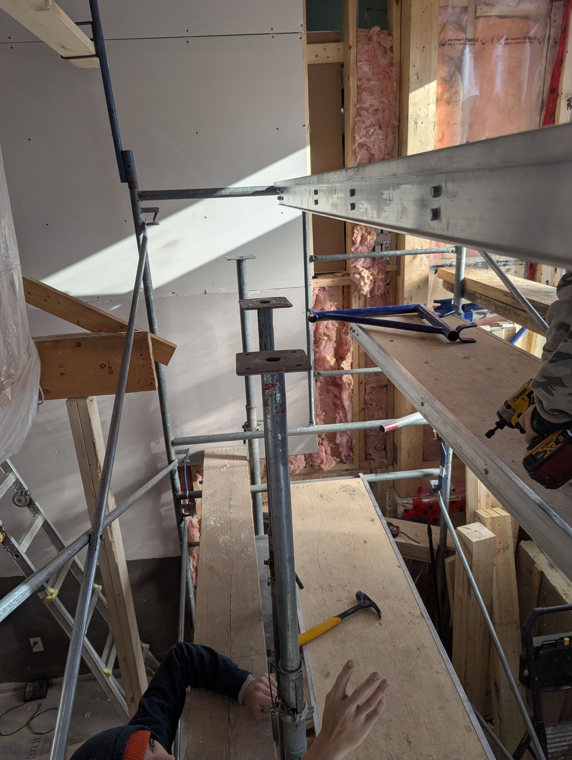 Un homme est allongé sur un échafaudage dans un bâtiment.