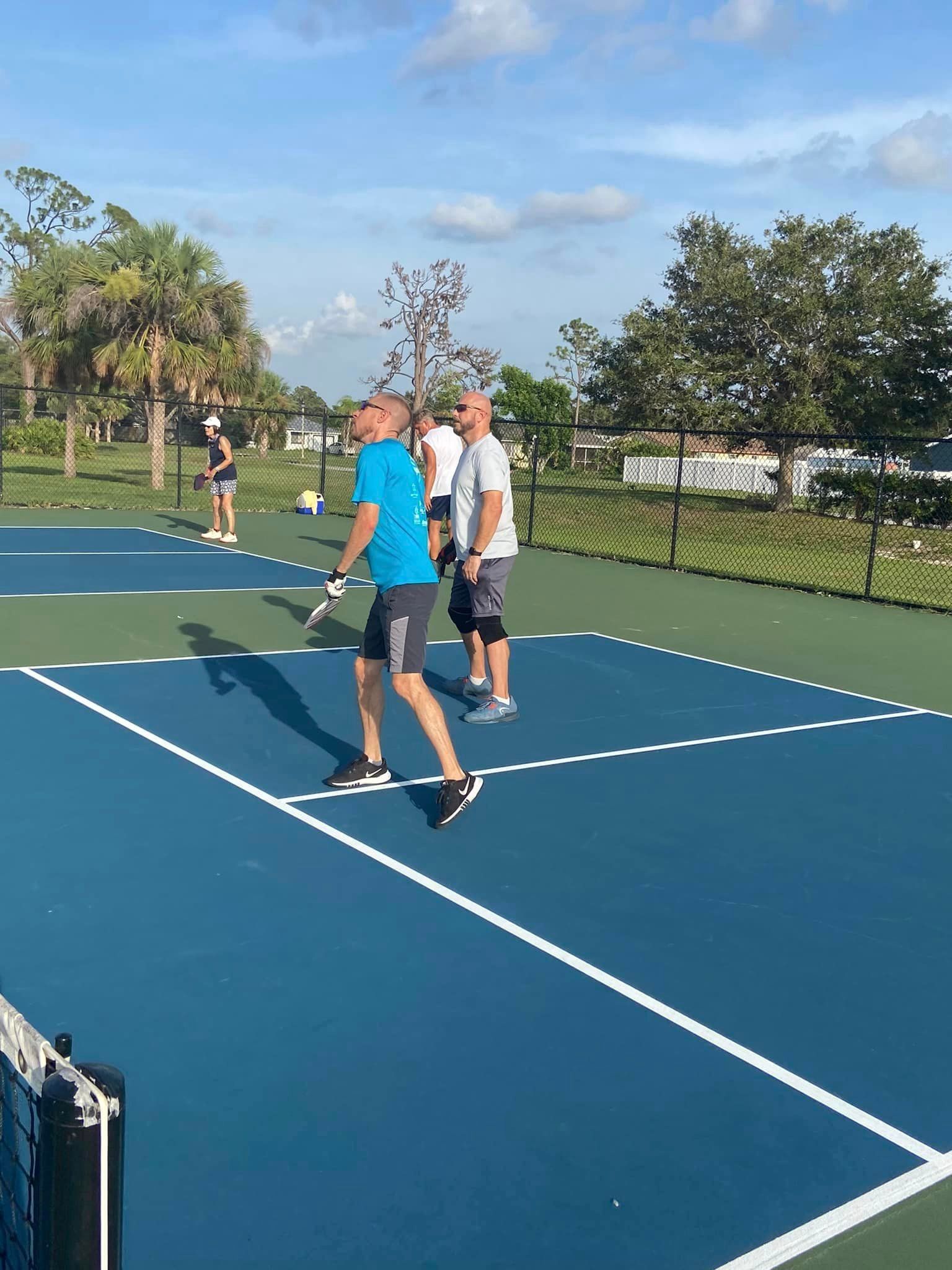 People Playing Pickleball on A Blue Court — North Port, FL — Team Doogie