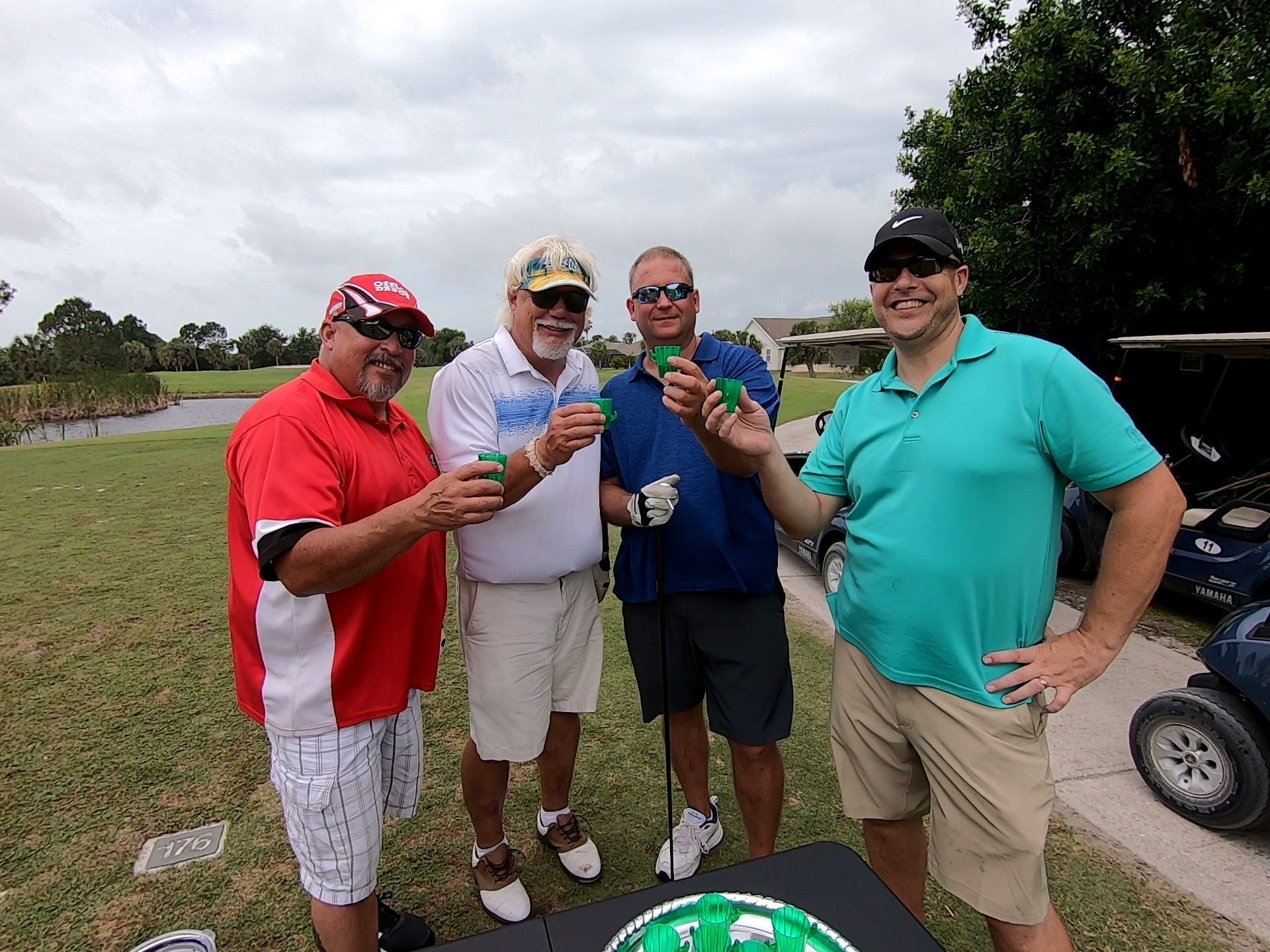 Men Standing Next to A Golf Course Holding Drinks — North Port, FL — Team Doogie