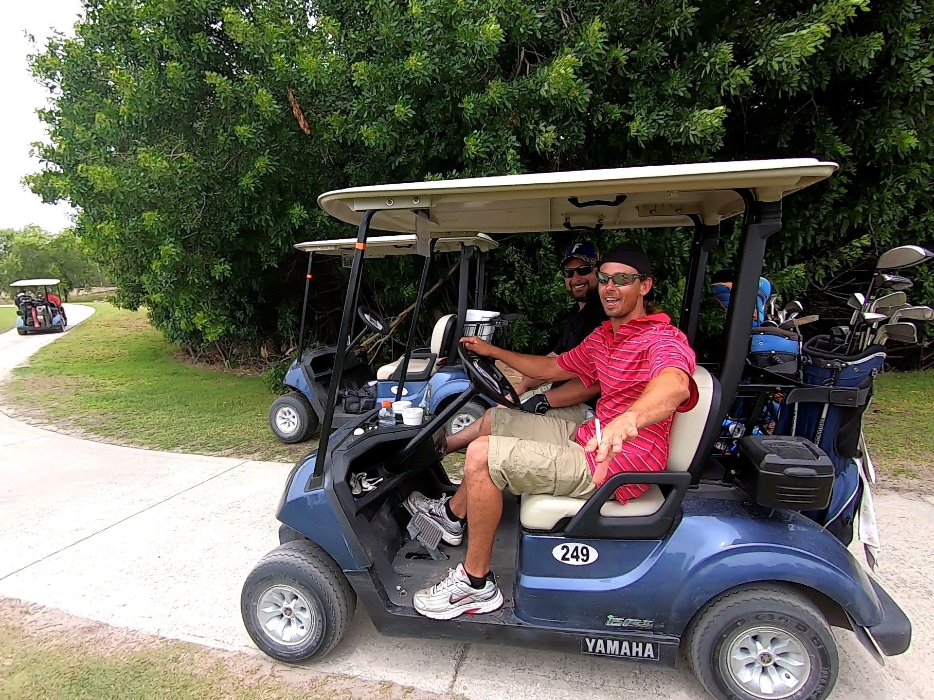 Two Men Are Sitting in A Golf Cart — North Port, FL — Team Doogie