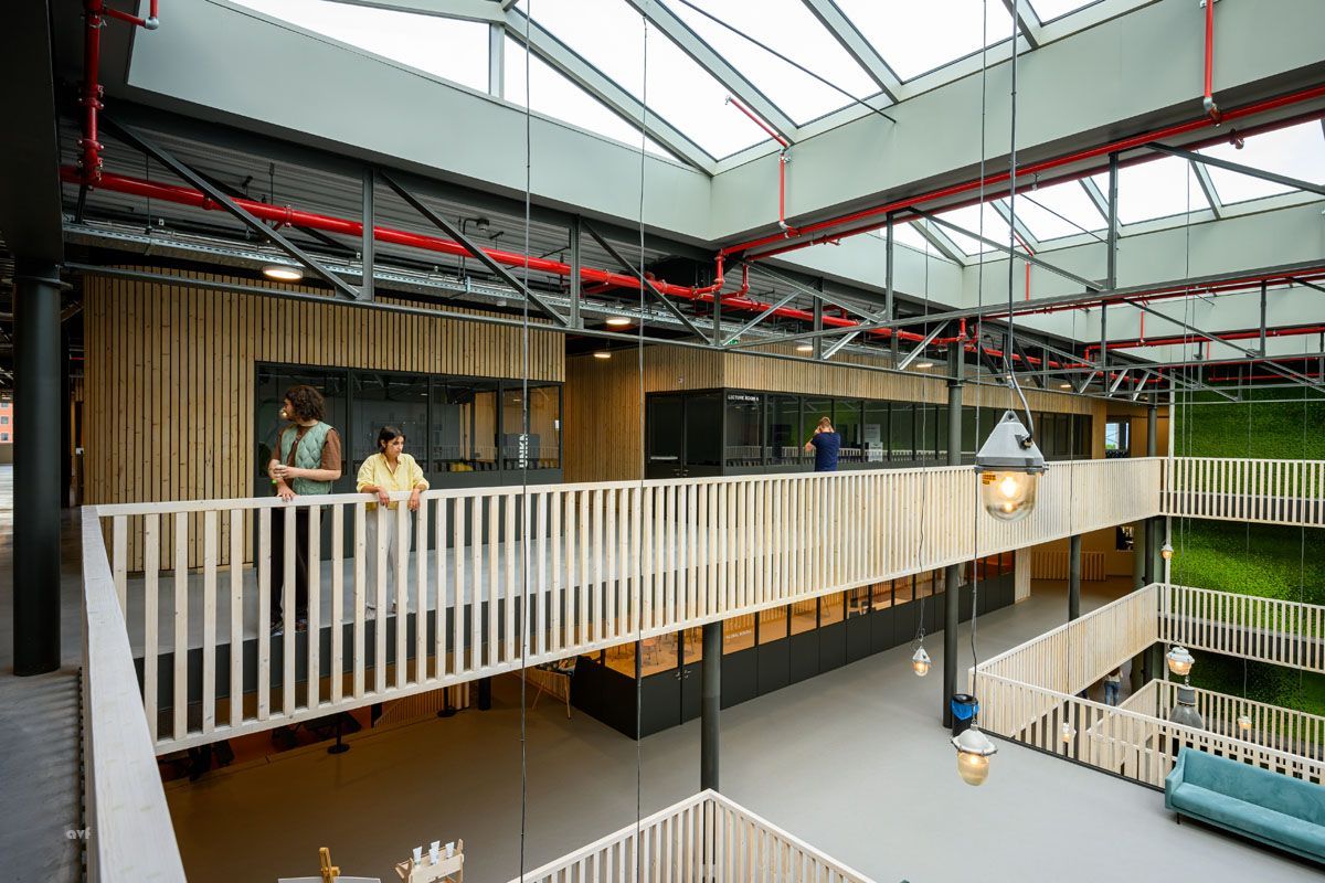 A group of people are standing on a balcony in a building.