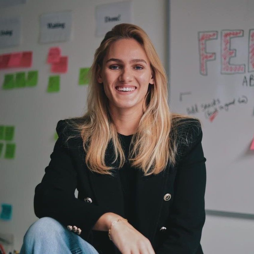 A woman sitting in front of a white board with the word feb written on it