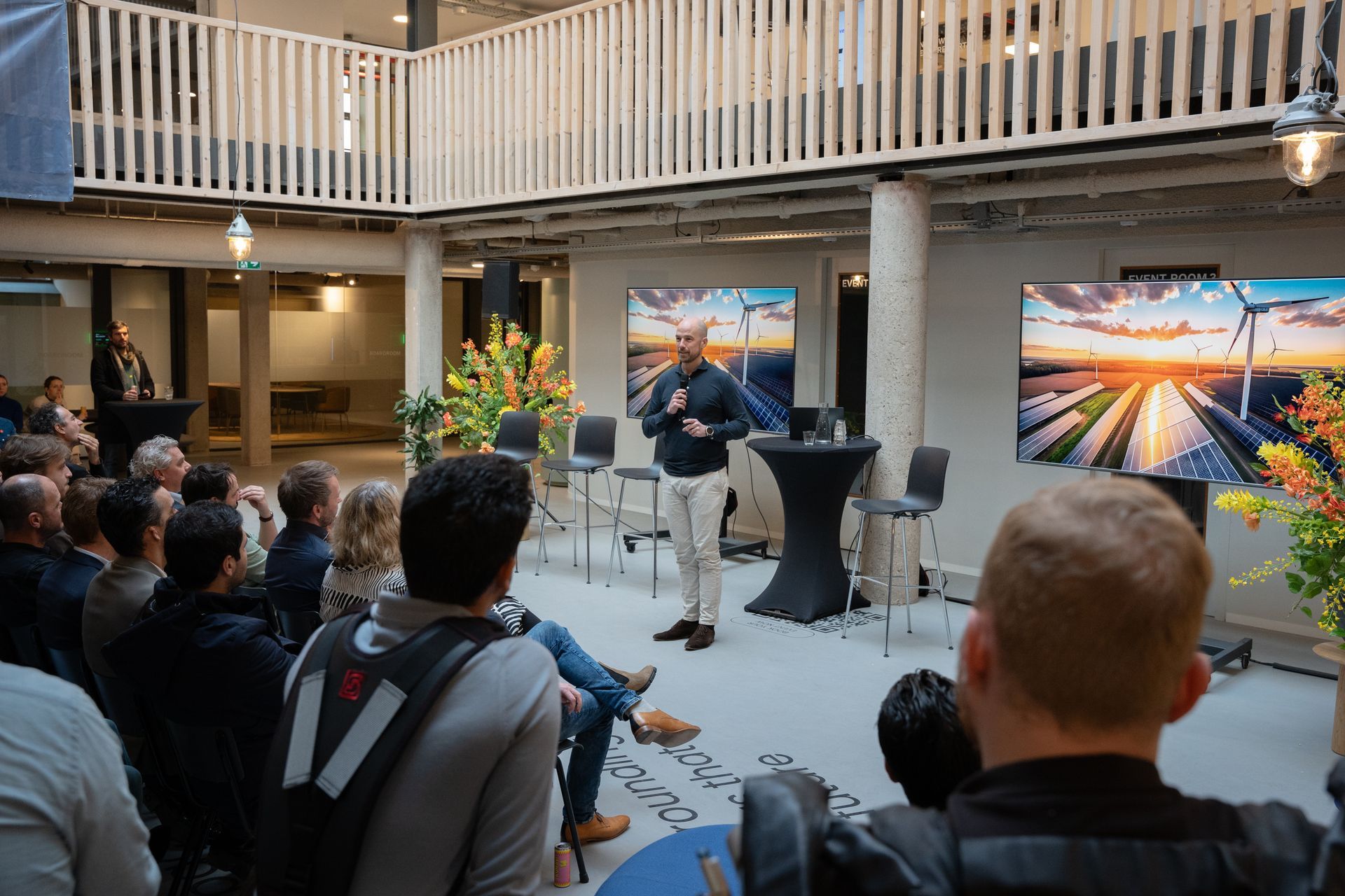 A man and a woman are standing next to each other talking into microphones.
