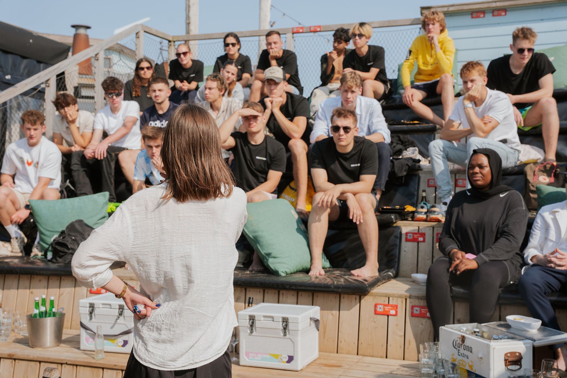 A group of people are standing around a table talking to each other.