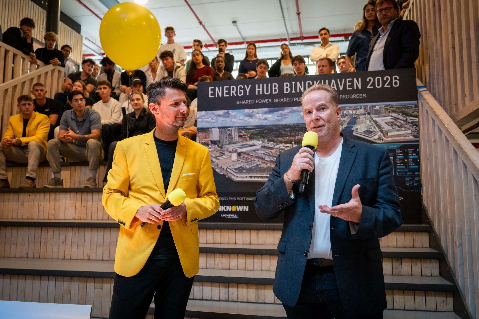 A group of people are standing on a stage throwing their hats in the air.