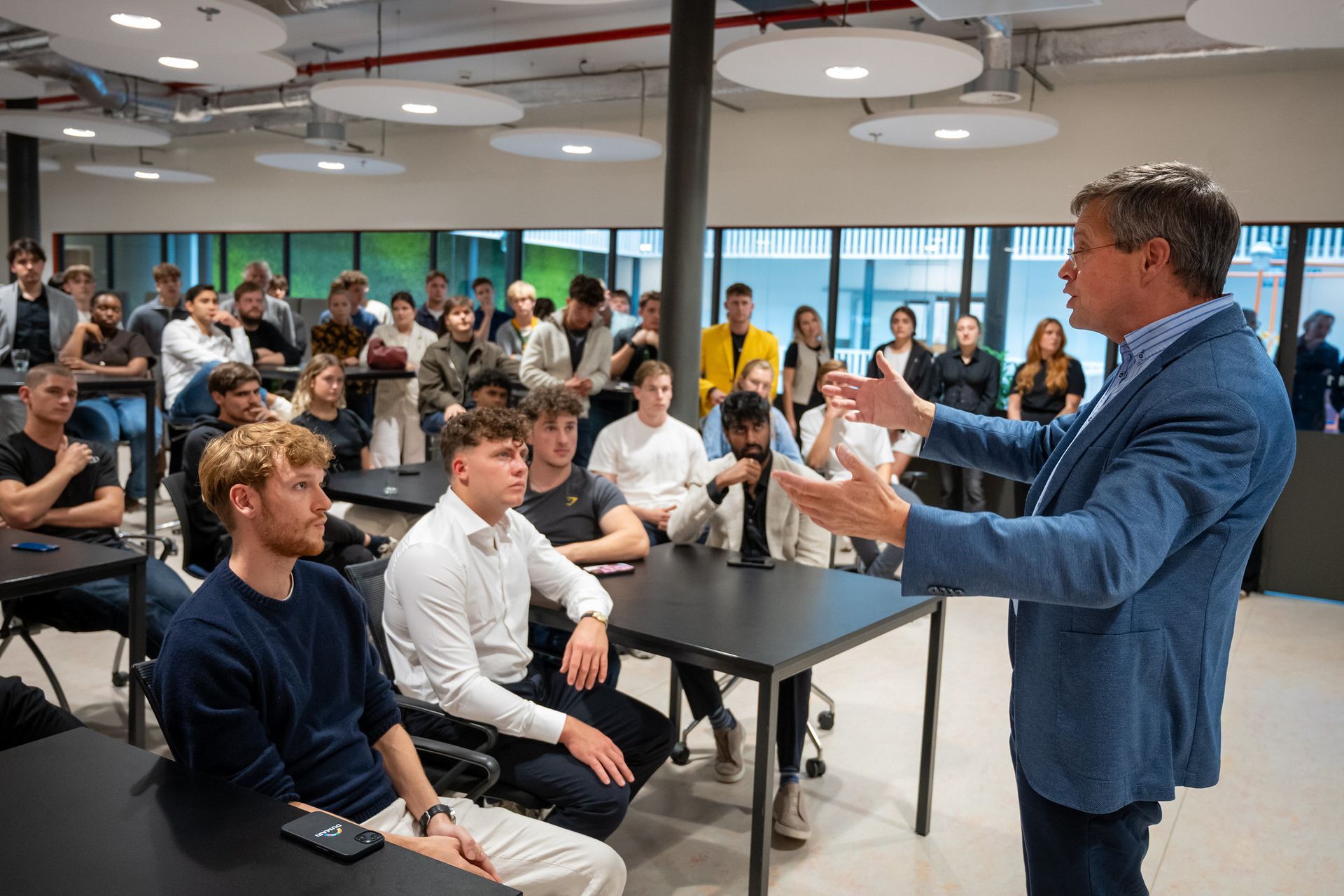 A group of people are sitting at desks in an office.