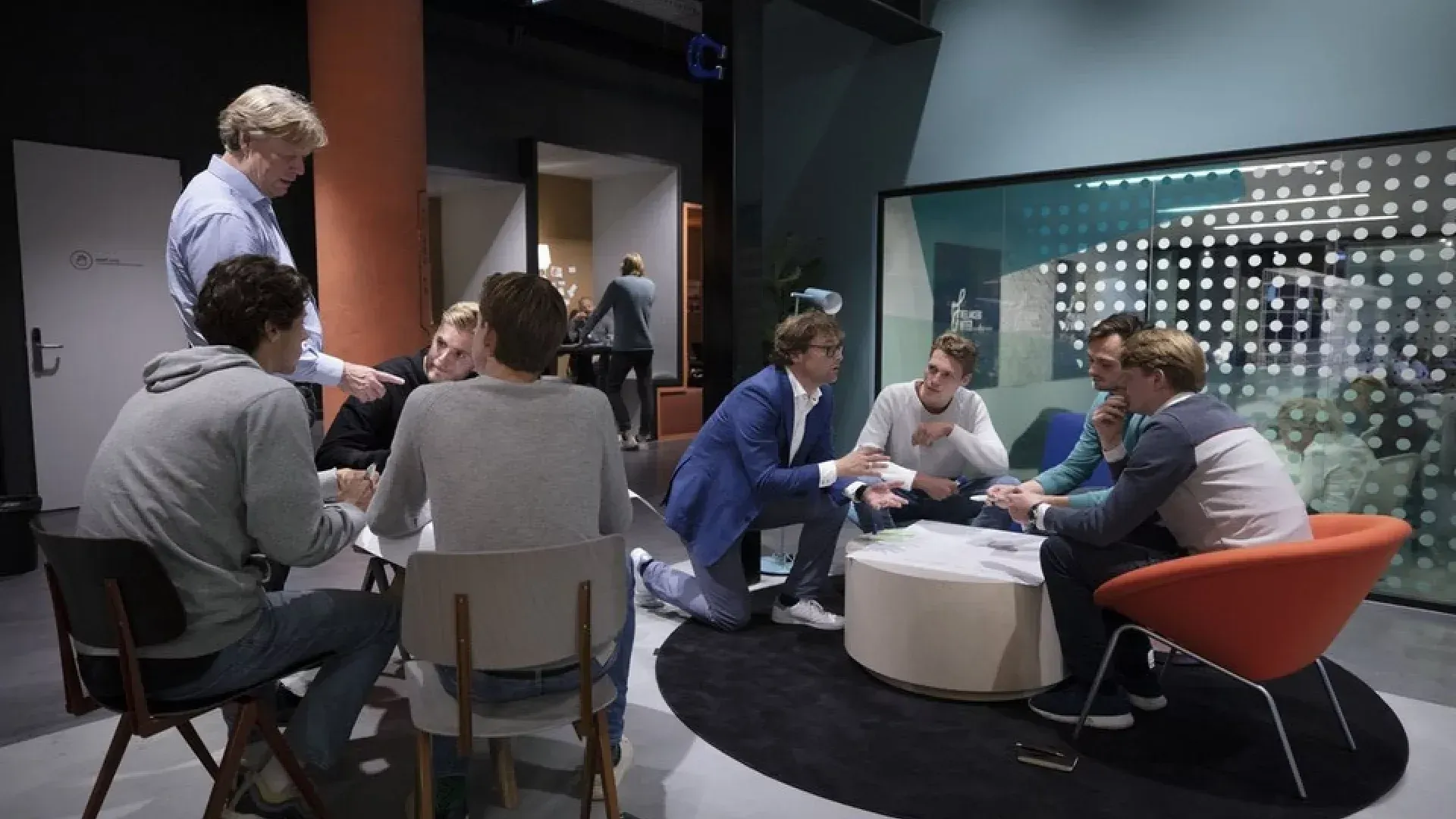 A group of people are sitting around a table in a room.