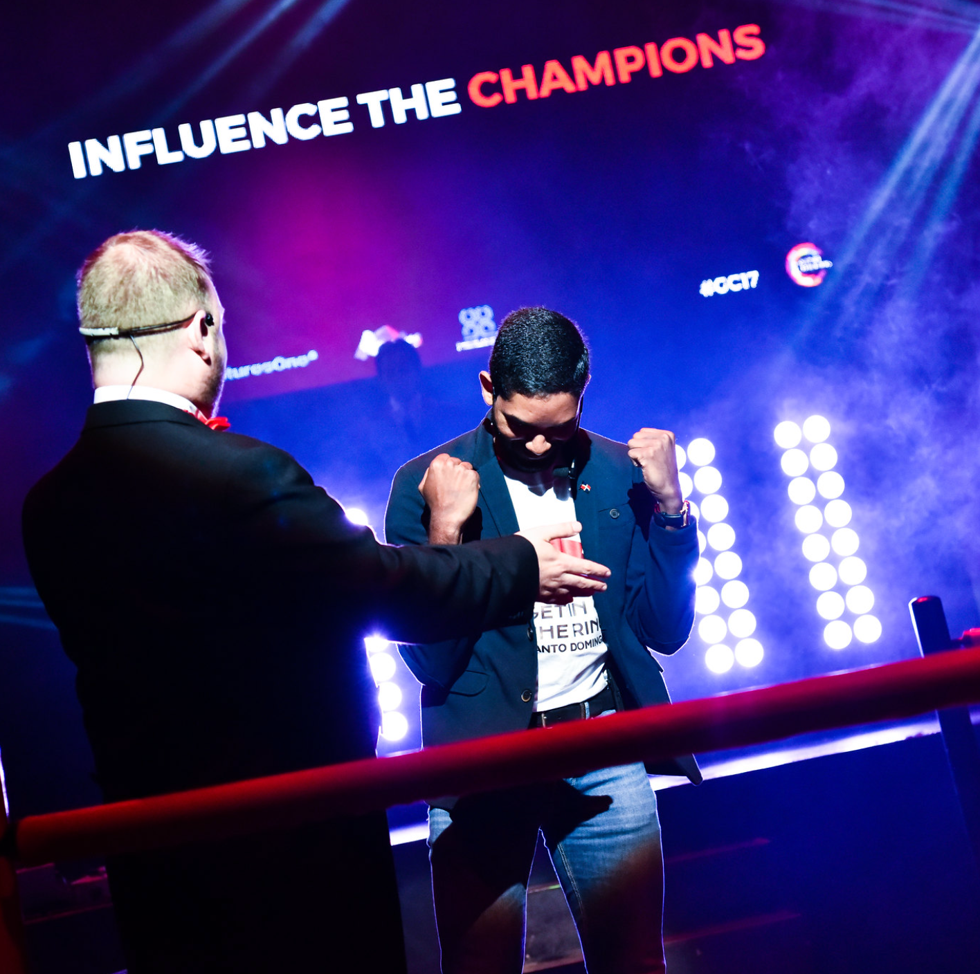Two men standing in front of a sign that says influence the champions