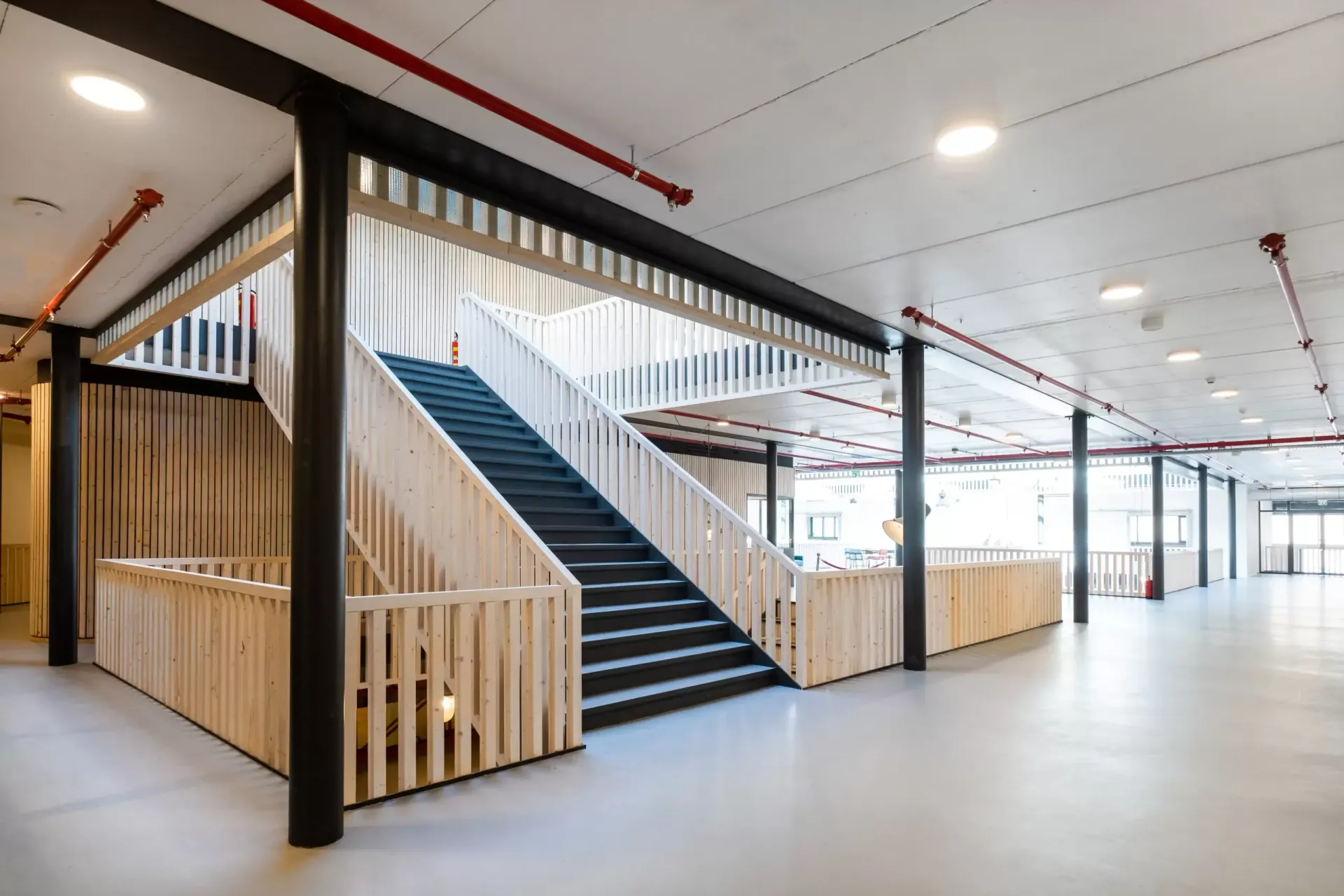 A staircase in a large building with a wooden railing.