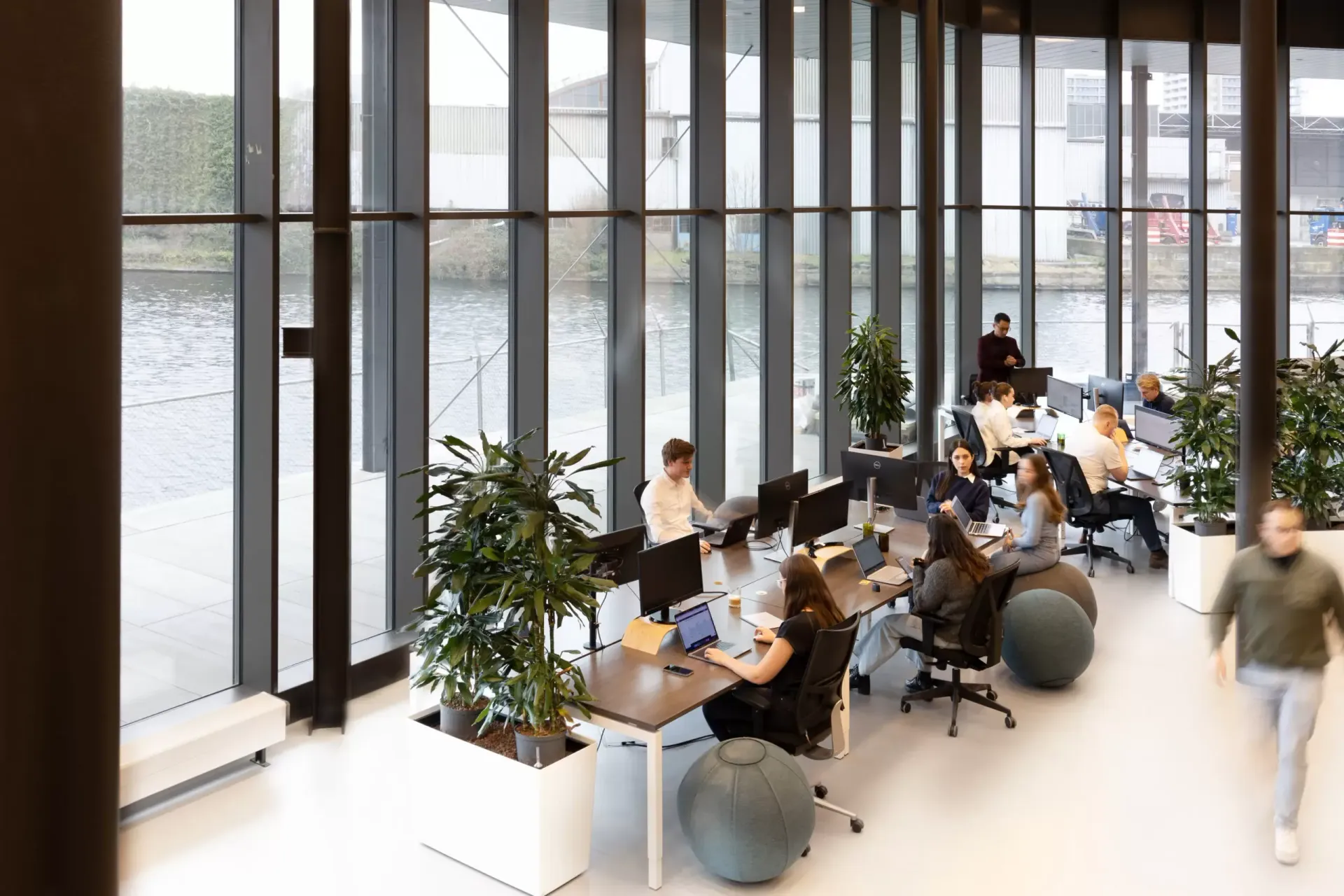 A group of people are sitting at desks in an office.