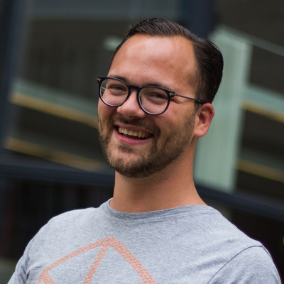 A man with glasses and a beard is smiling for the camera.