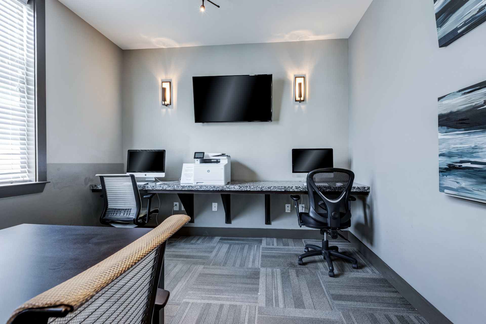 Office space with computers, printer, TV, and office chairs at Town Center at Lake Carolina in Columbia, SC.