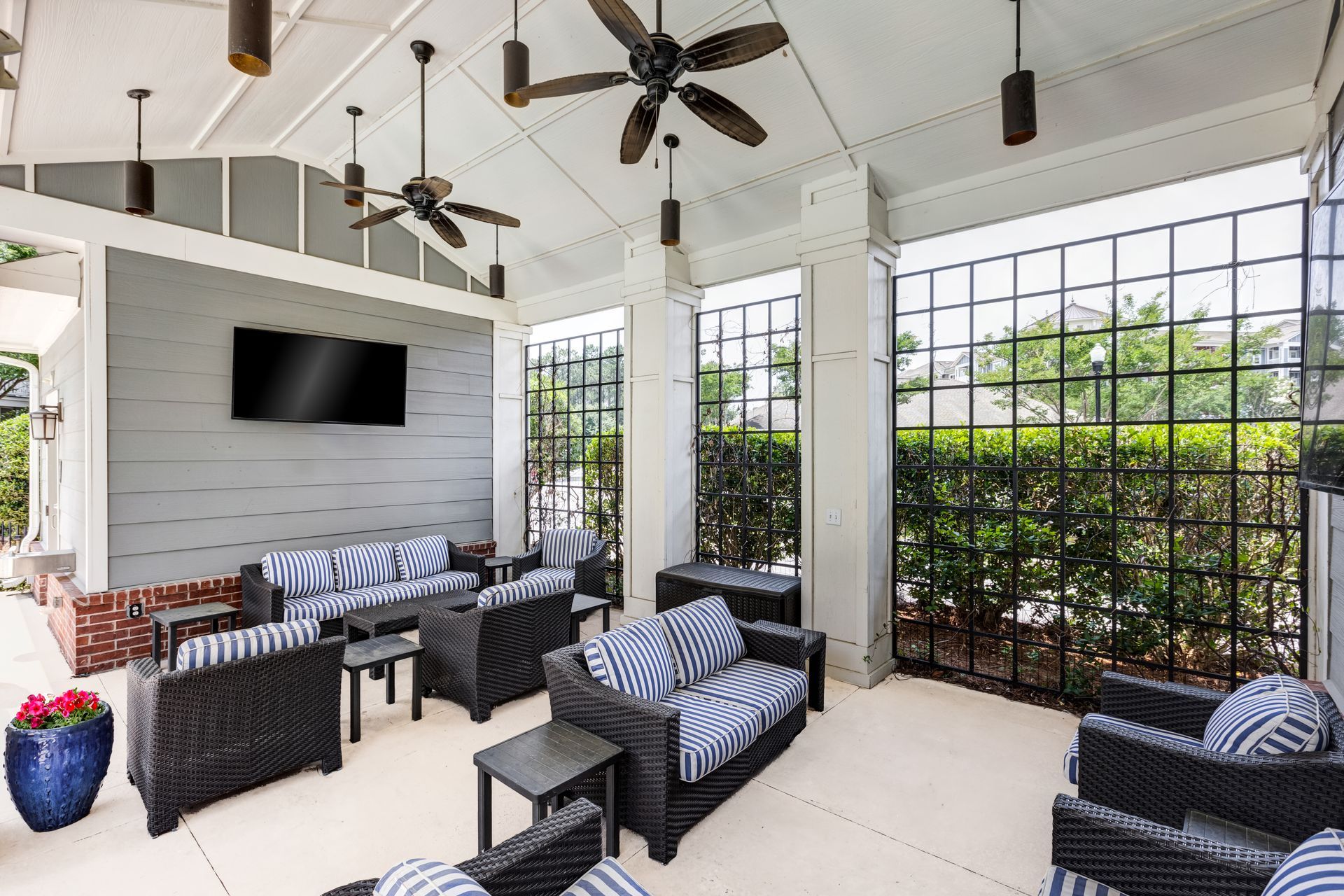 Covered outdoor patio with seating, ceiling fans, and a television at Town Center at Lake Carolina in Columbia, SC.