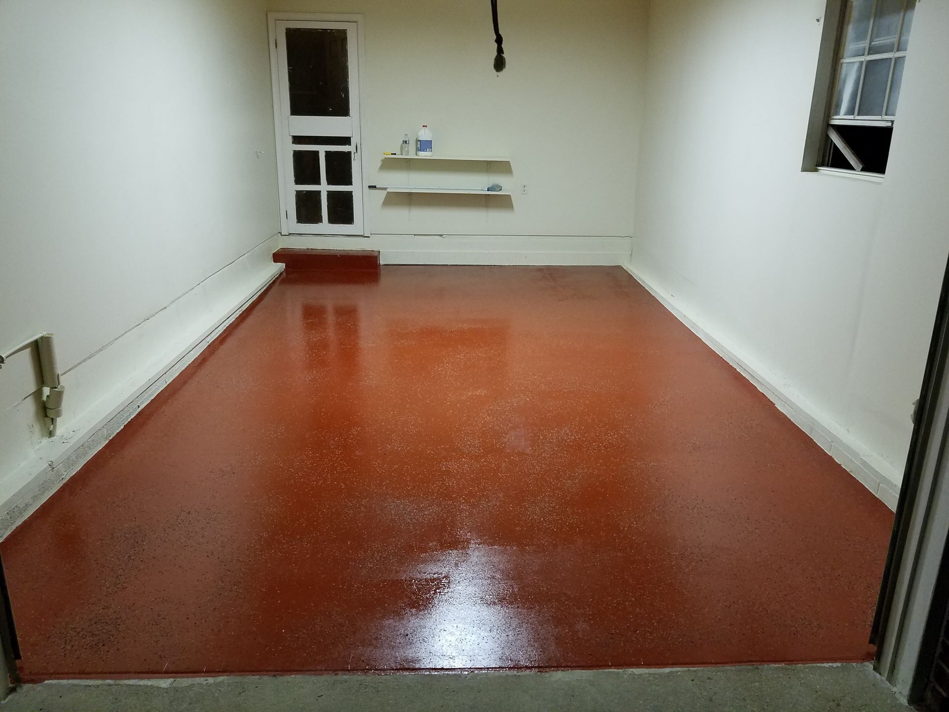 A garage with a red floor and white walls