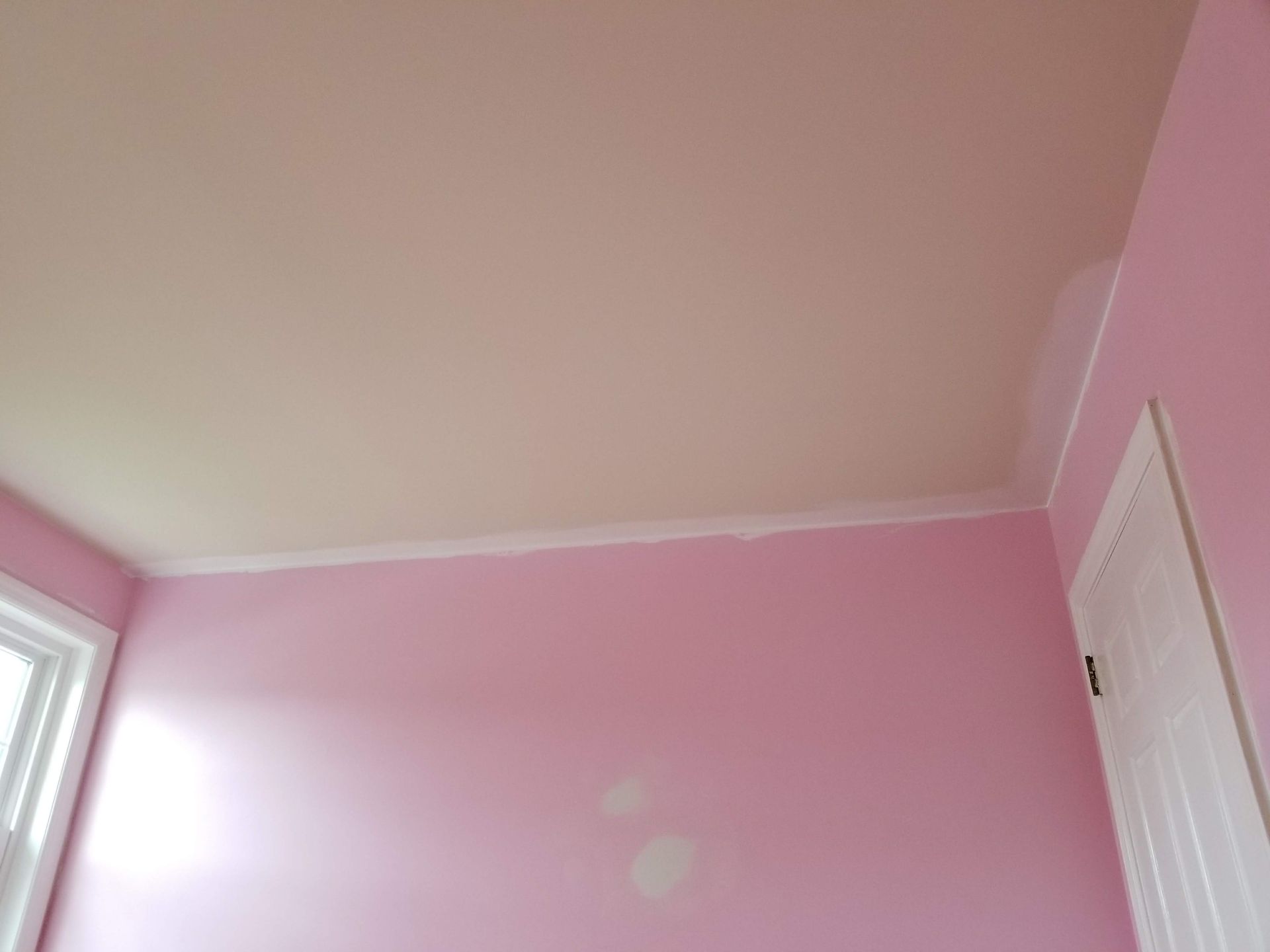 A room with pink walls and a white ceiling.