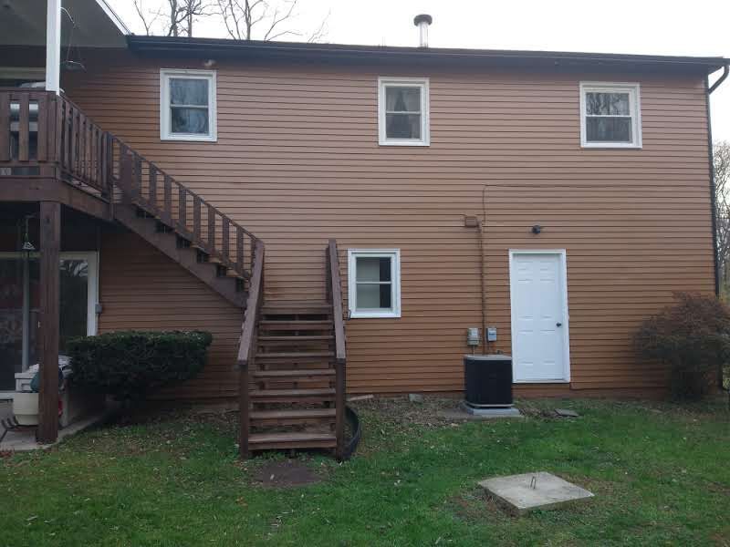 The back of a house with stairs leading up to the second floor.