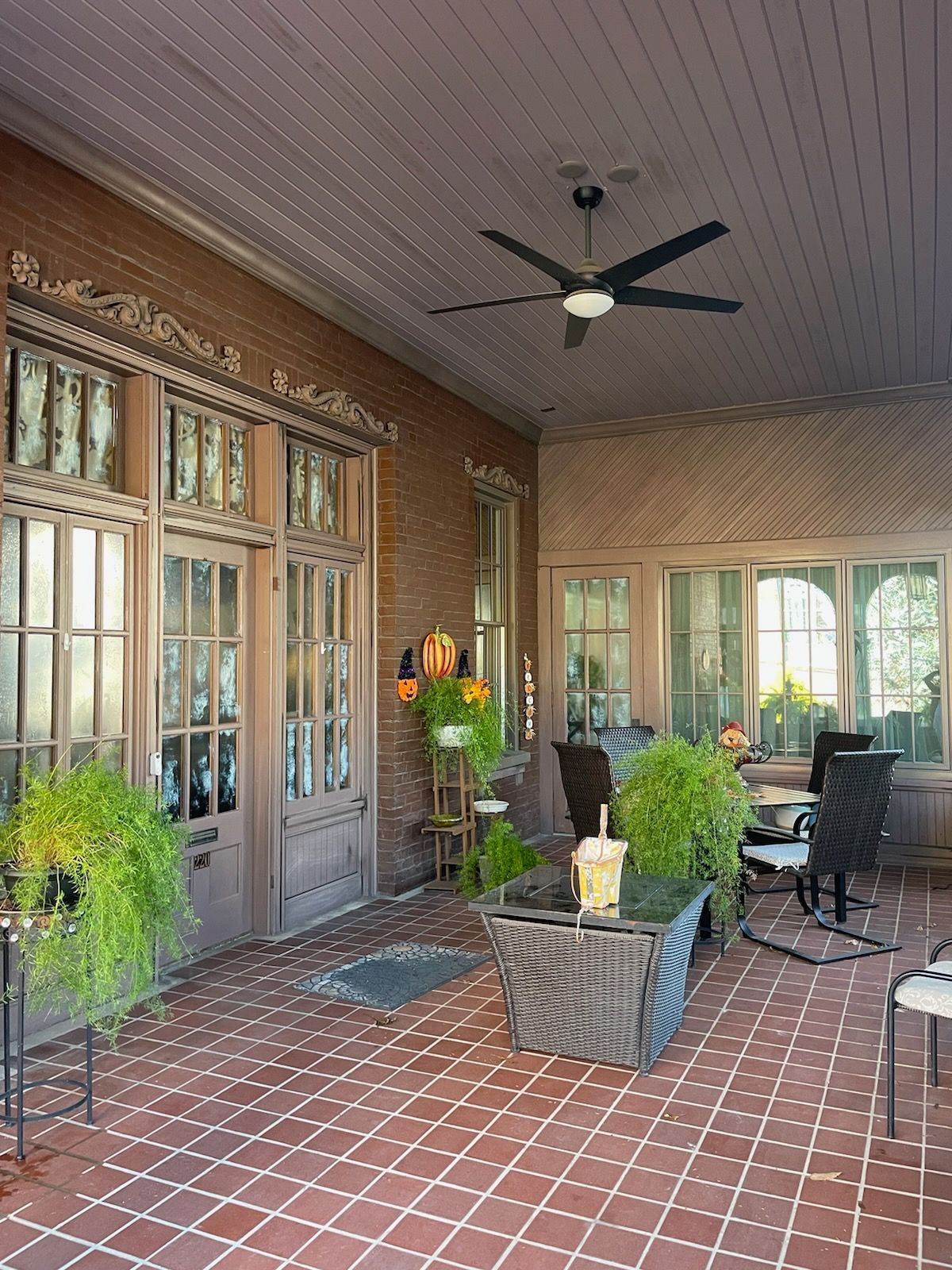 A patio with a ceiling fan and a table and chairs