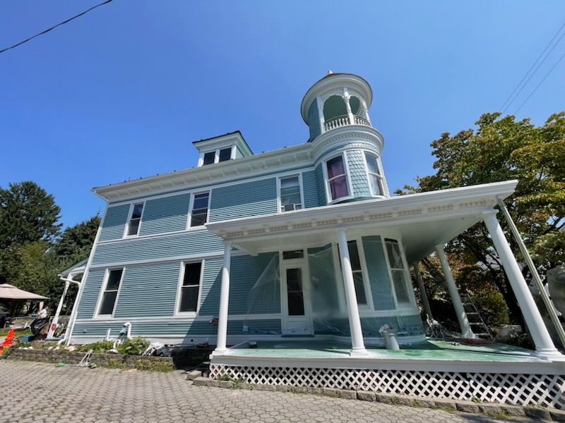 A large blue house with a tower on top of it