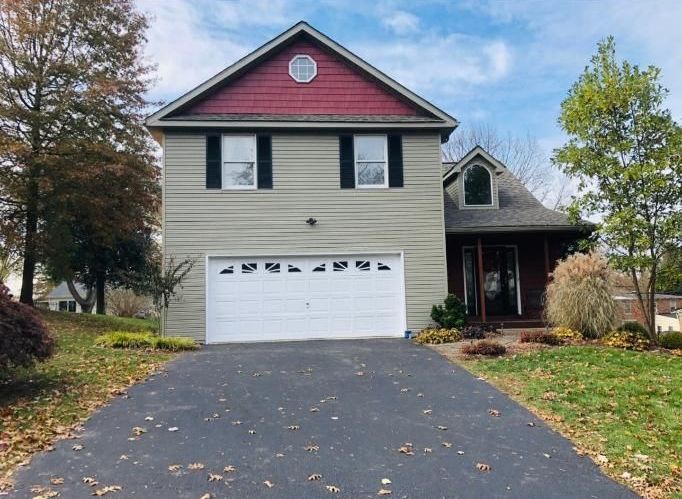 A house with a red roof and a white garage door