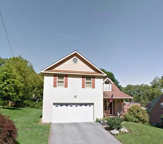 A white house with red shutters and a garage