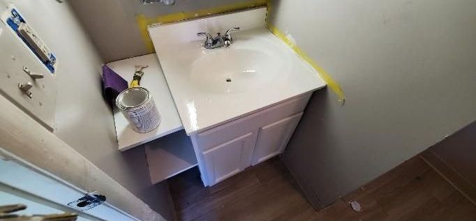 A bathroom with a sink and a mirror in it.