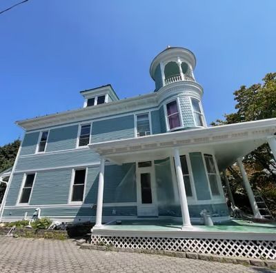 A large blue house with a tower on top of it