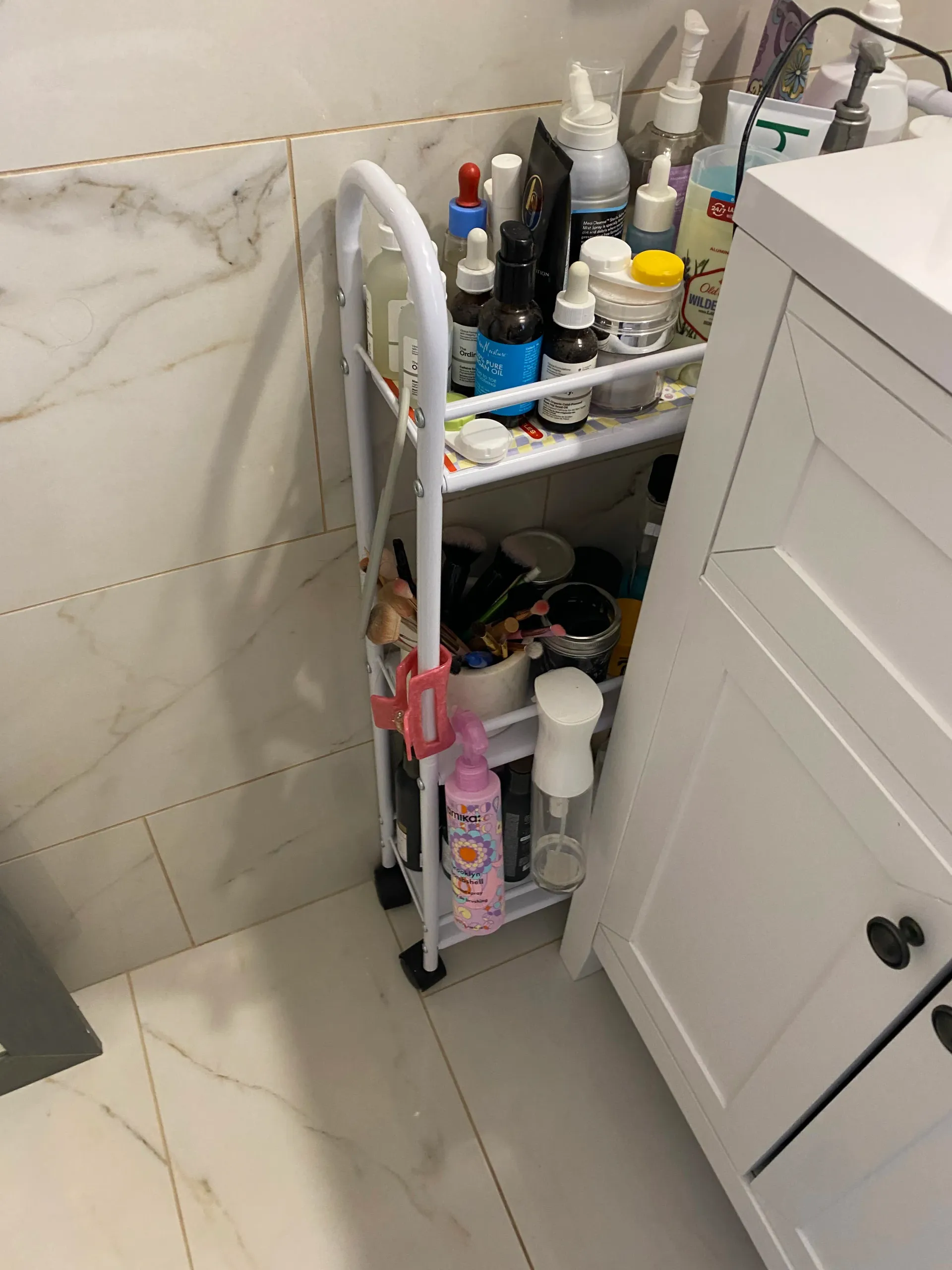 A bathroom cart filled with lots of bottles and cosmetics.