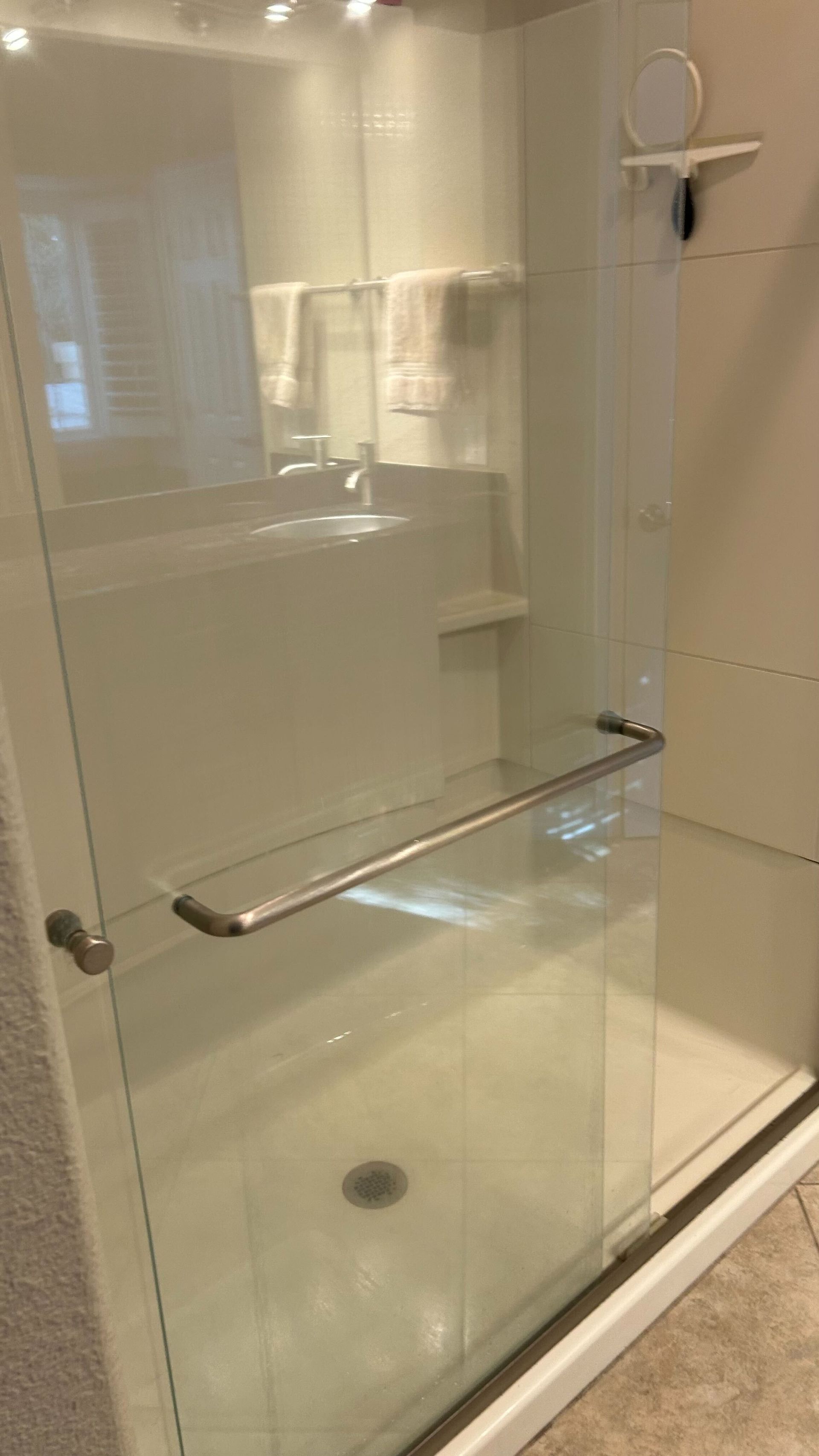 A bathroom with a walk in shower and a sink.