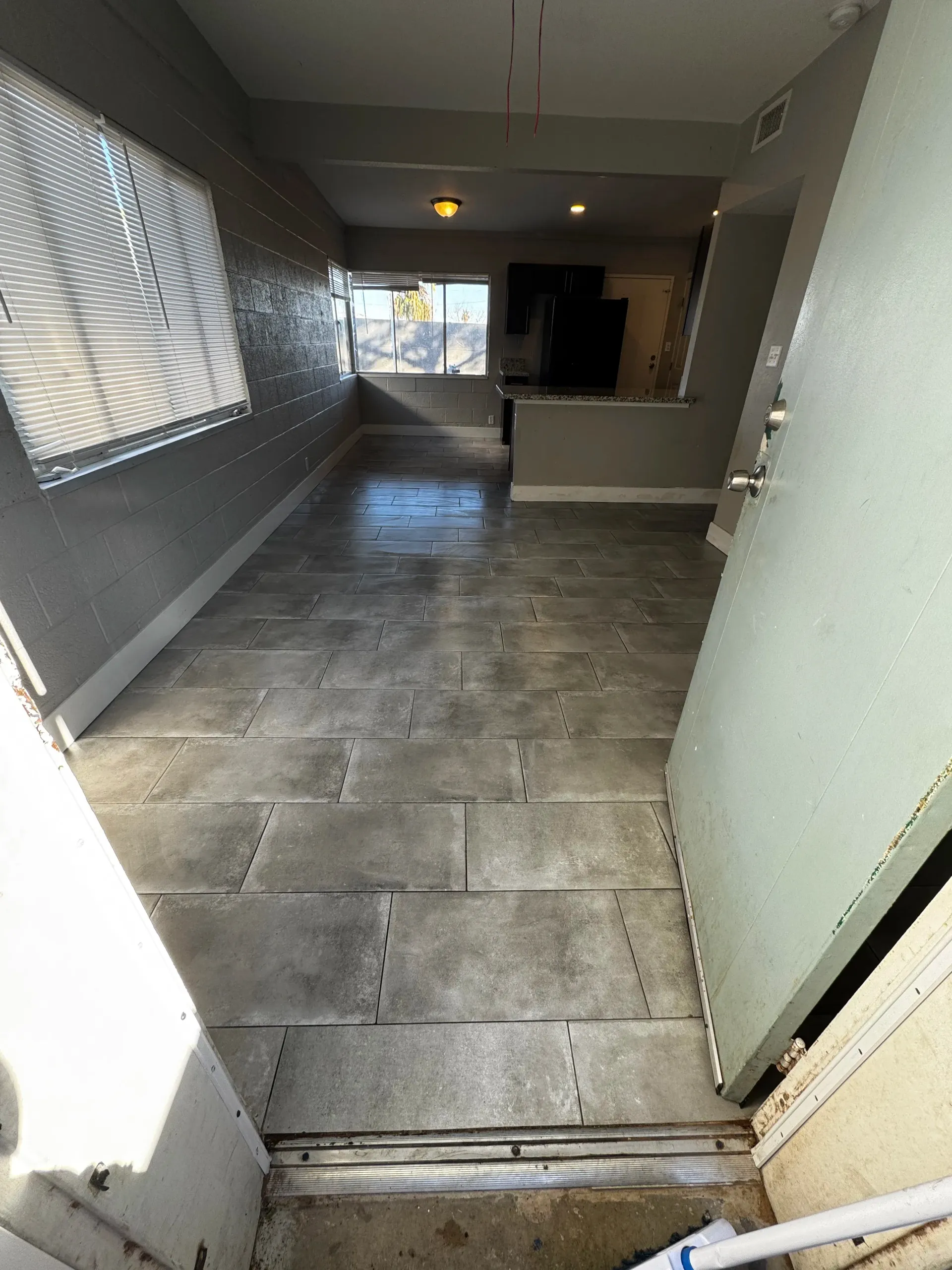 An empty room with a tiled floor and a window.