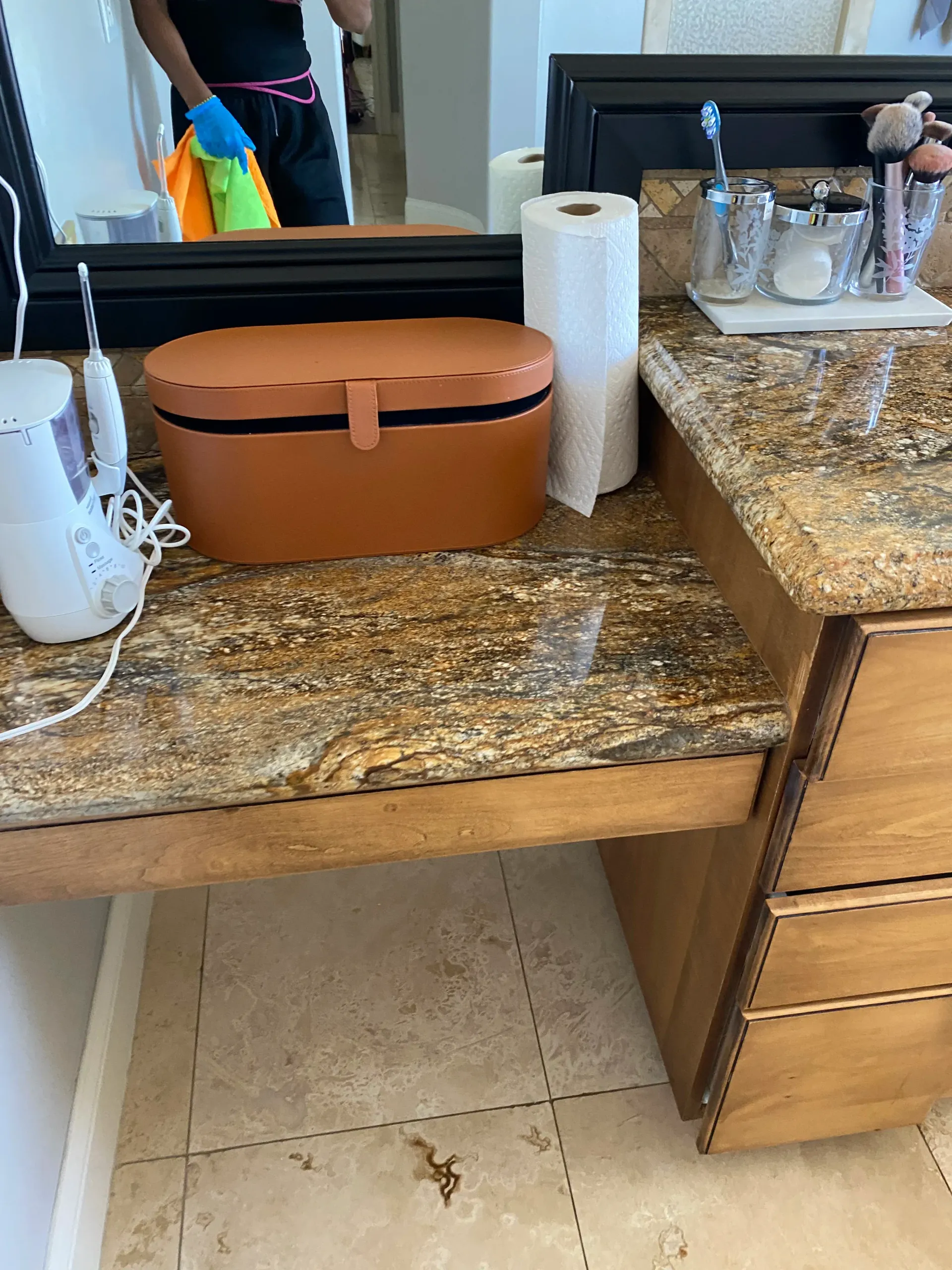 A bathroom counter with a mirror and a box on it.