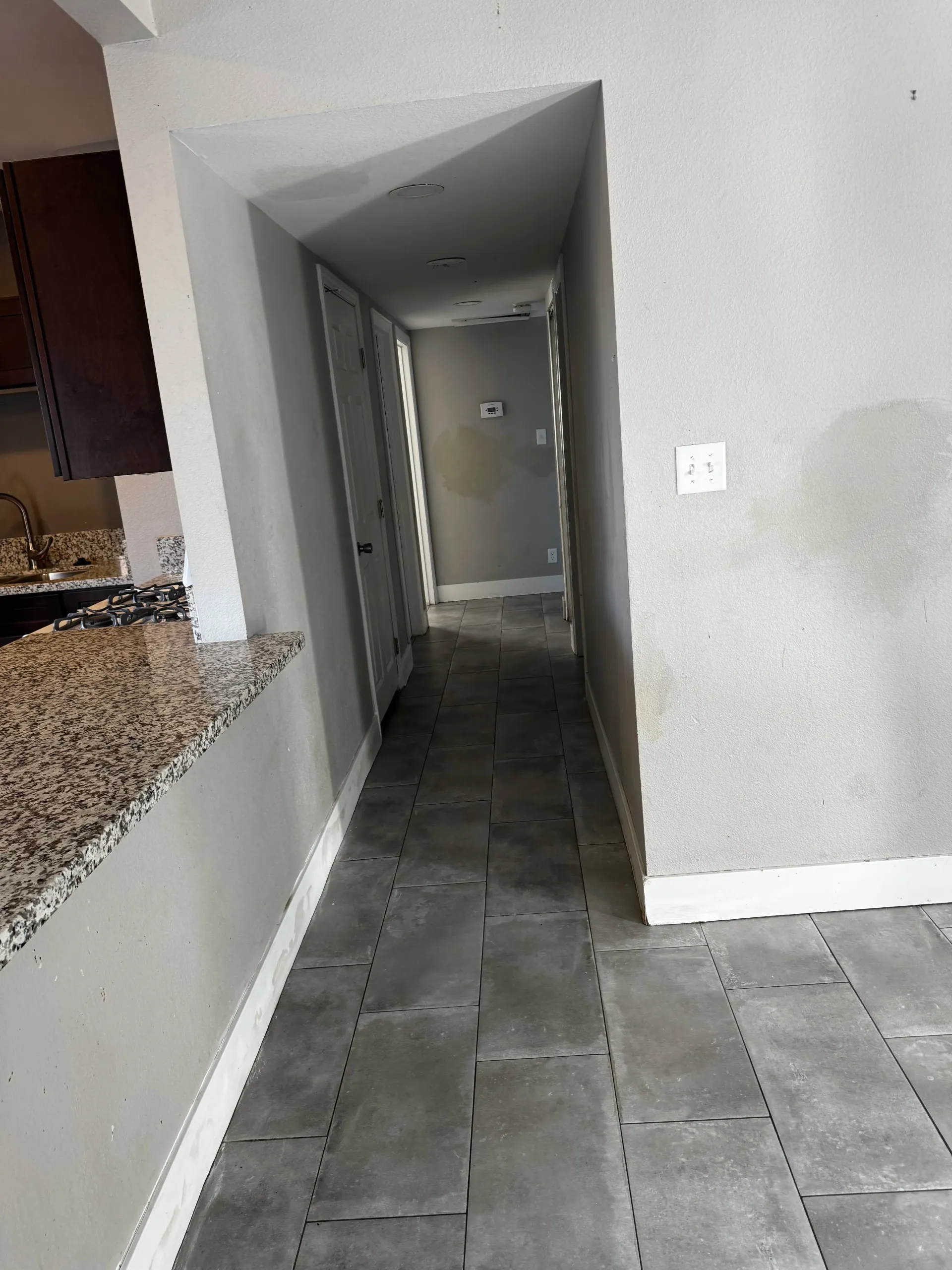 A hallway in a house with a tile floor