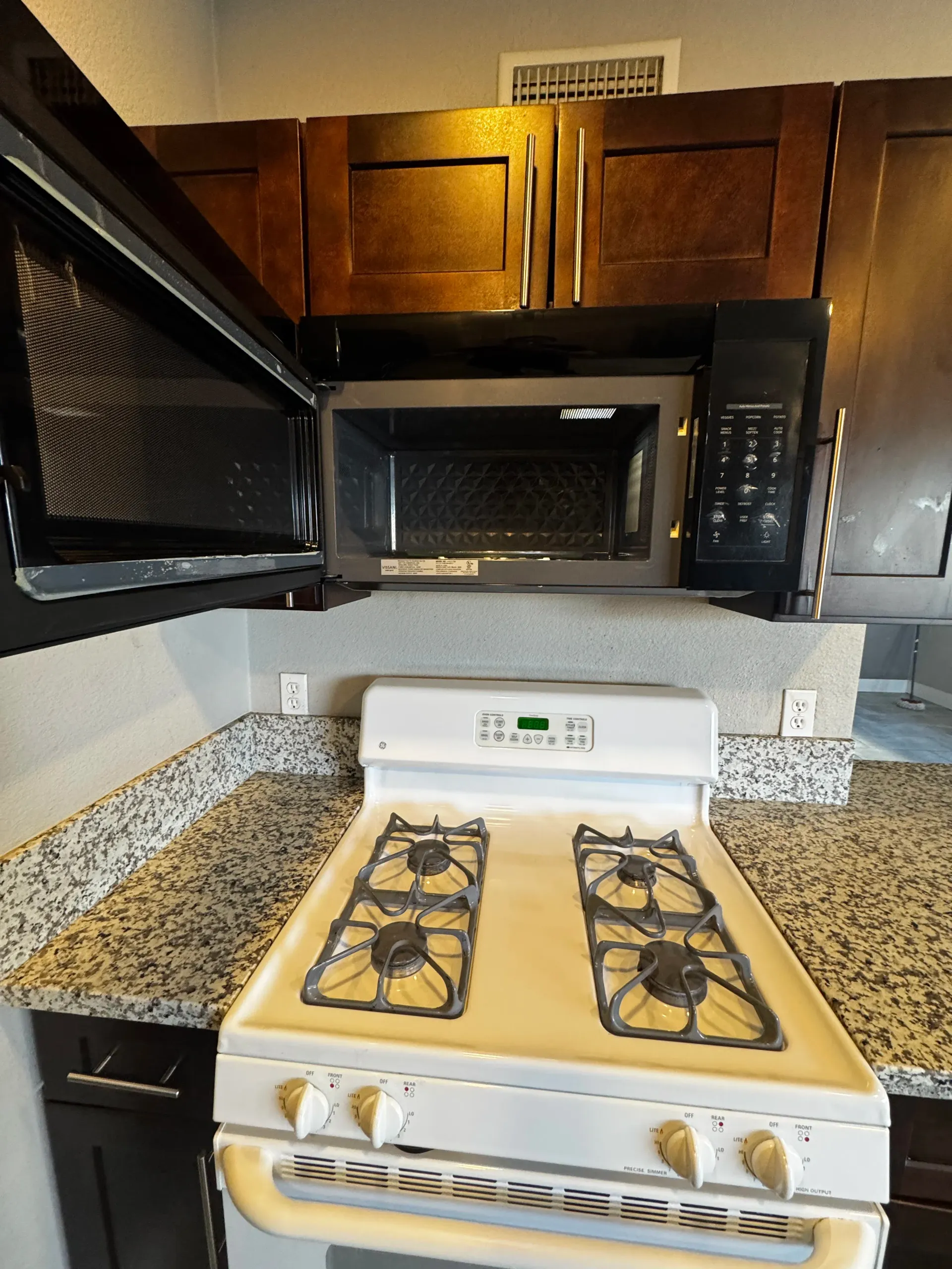 A kitchen with a stove top oven and a microwave
