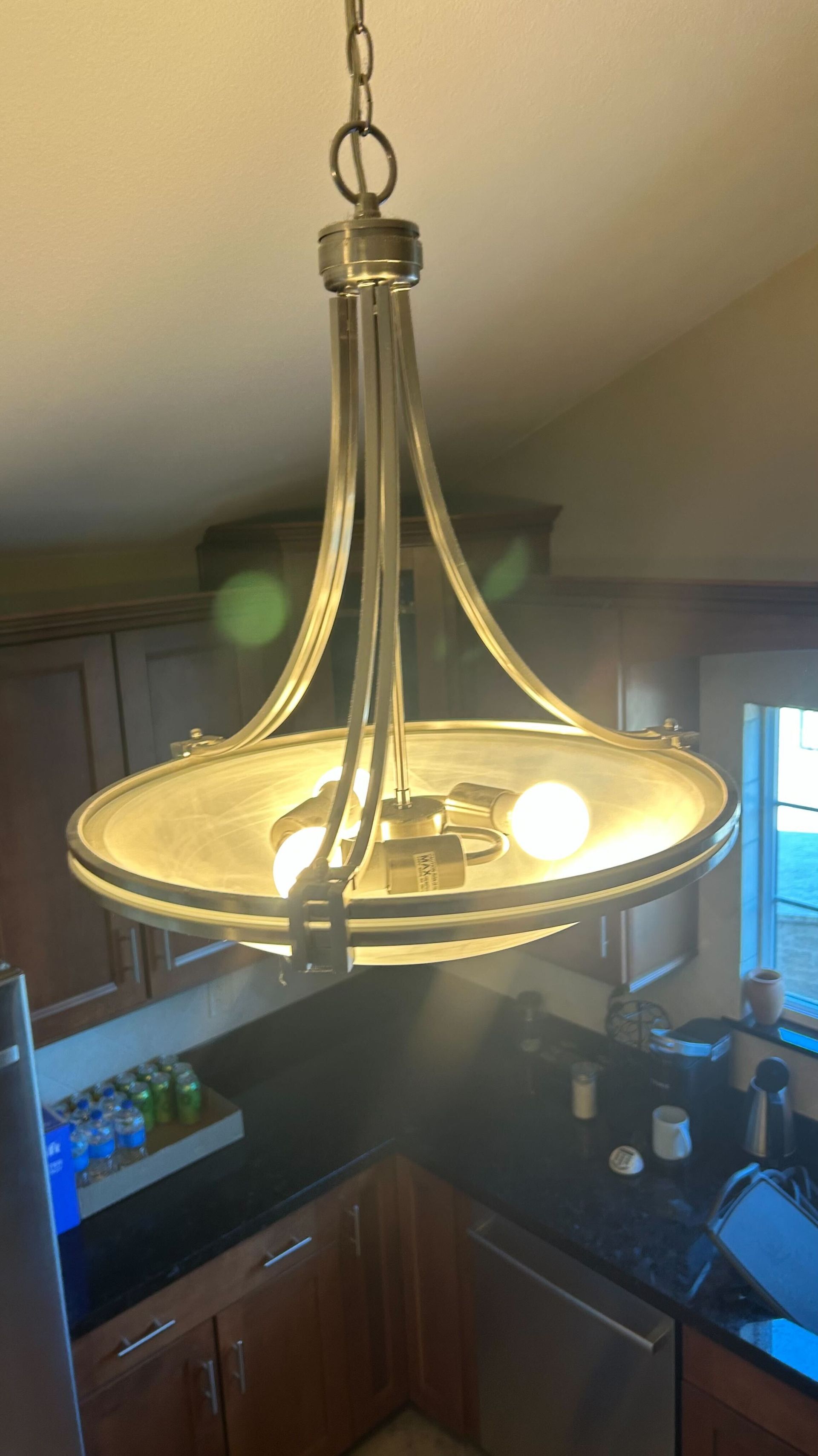 A chandelier is hanging from the ceiling in a kitchen.