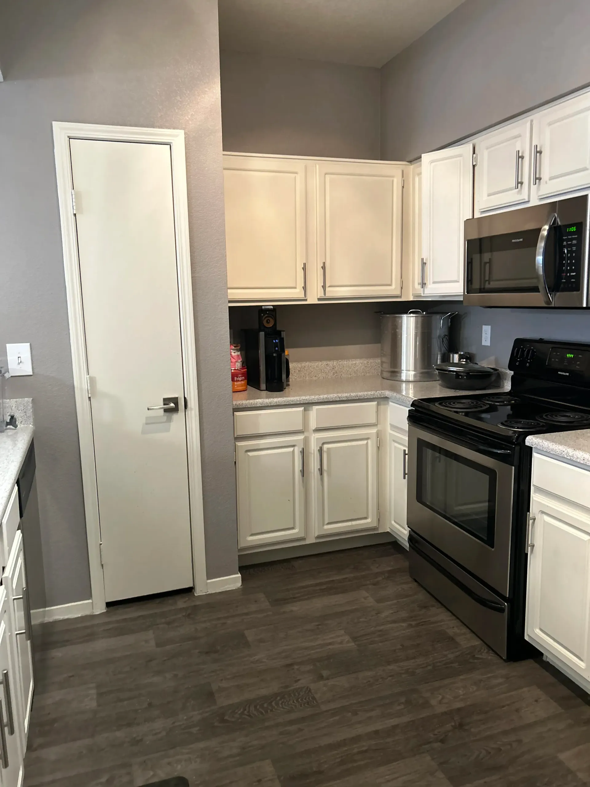 A kitchen with white cabinets and stainless steel appliances.