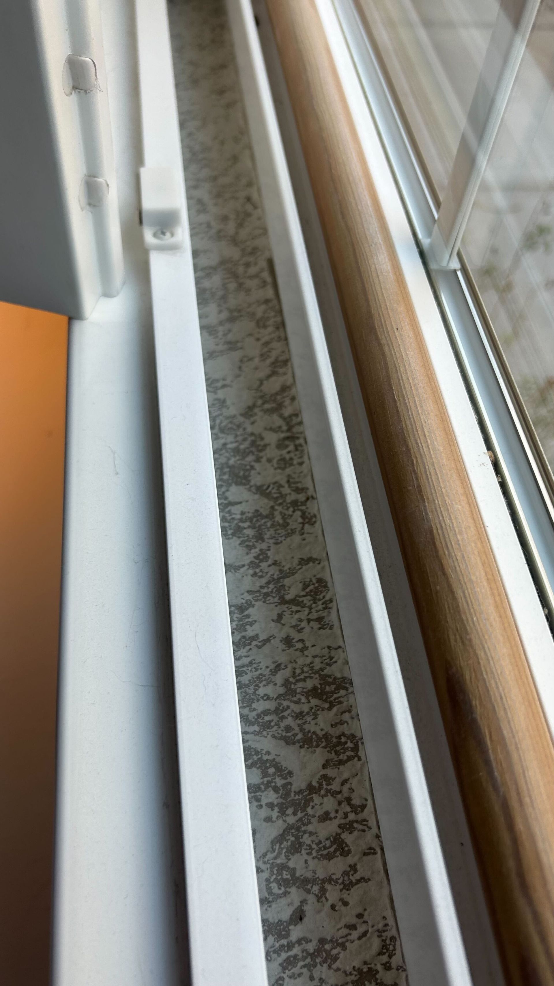 A close up of a window sill with a wooden frame.