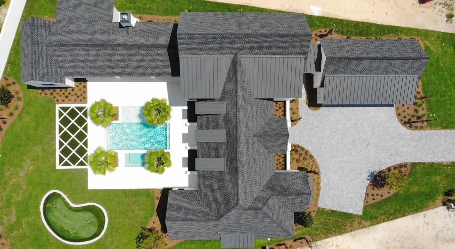 An aerial view of a large house with a pool in the backyard.