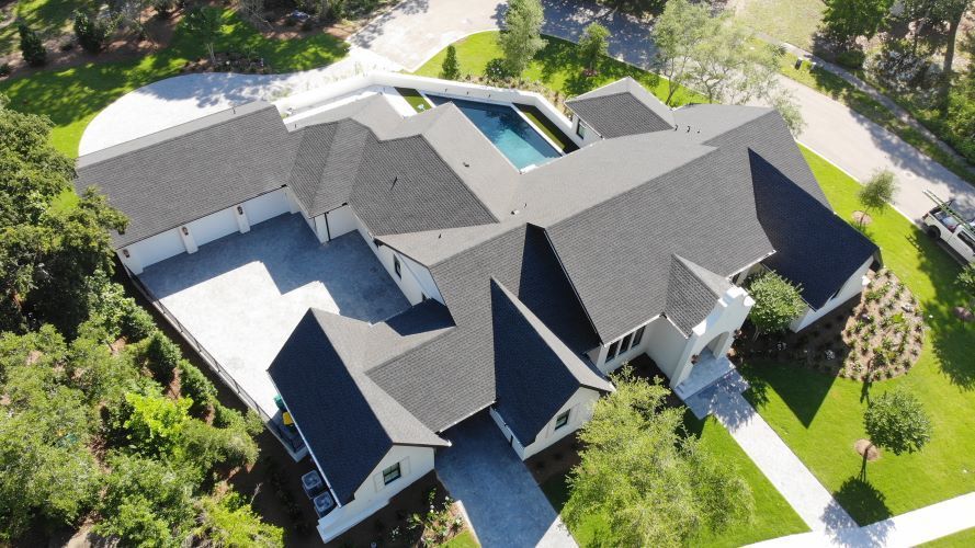 An aerial view of a large house with a pool in the backyard