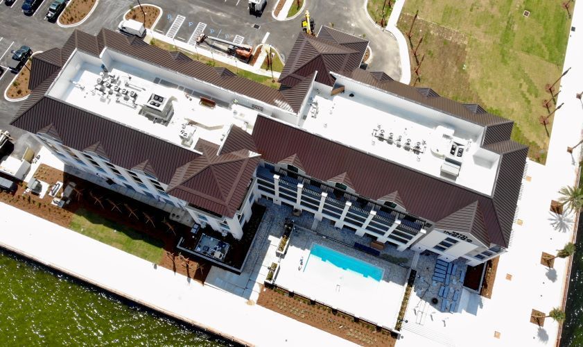 An aerial view of a large building with a pool in front of it.