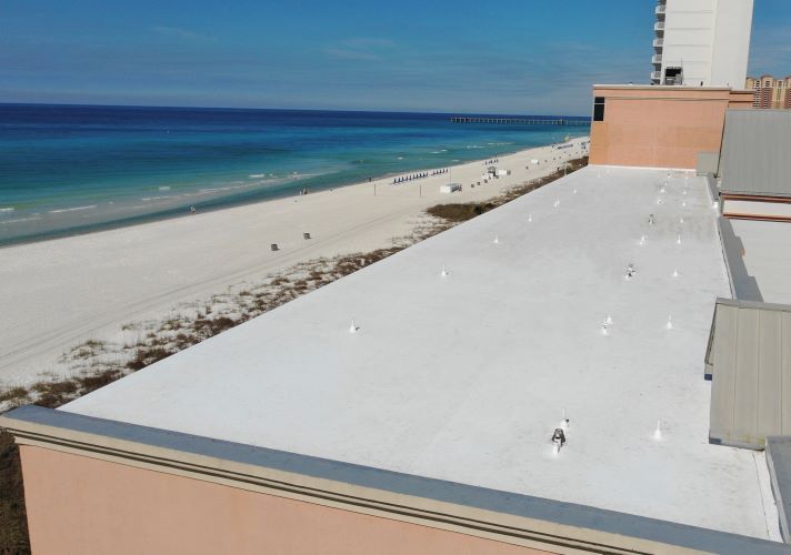 The roof of a building with a view of the beach and ocean.