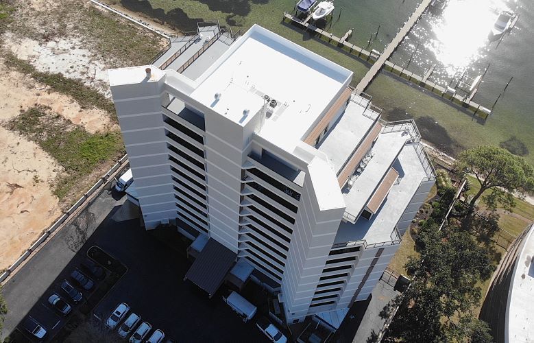 An aerial view of a tall building next to a body of water.