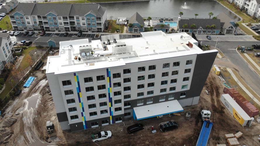 An aerial view of a large building under construction in a city.