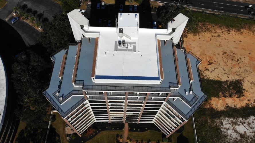 An aerial view of a large building with a white roof