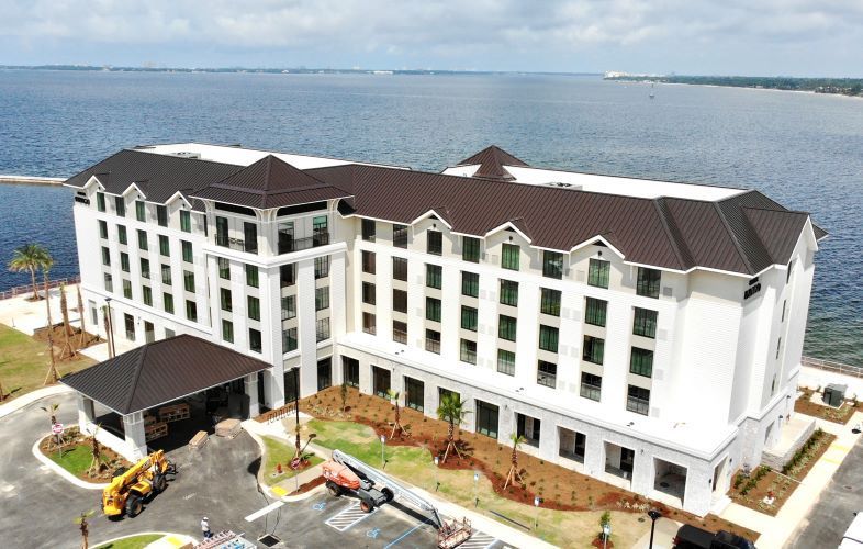 An aerial view of a large white building next to a body of water.