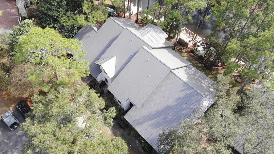 An aerial view of a large house surrounded by trees.