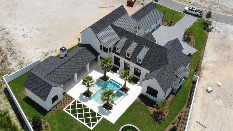 An aerial view of a large house with a pool