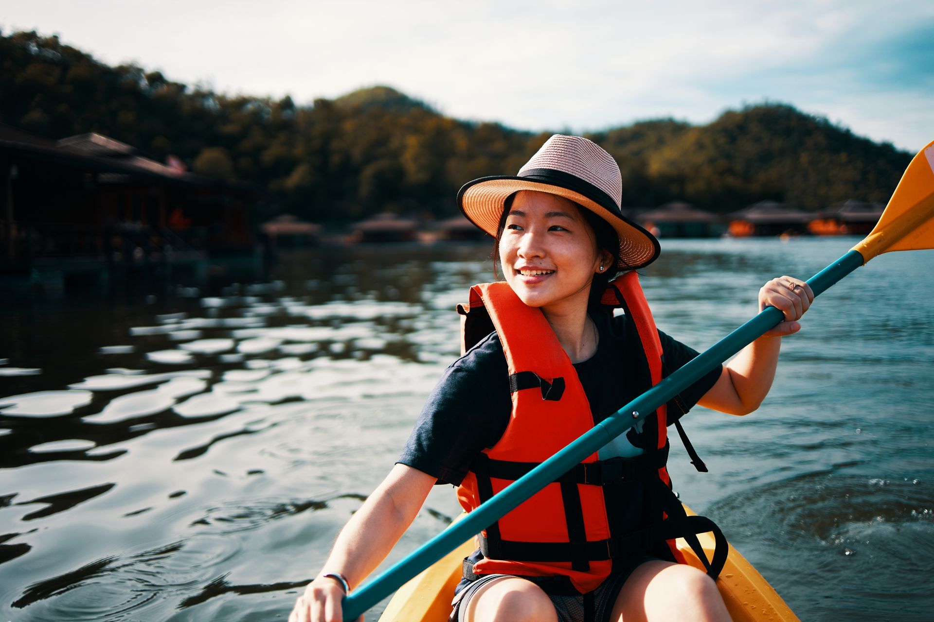 A woman is rowing a kayak on a lake.