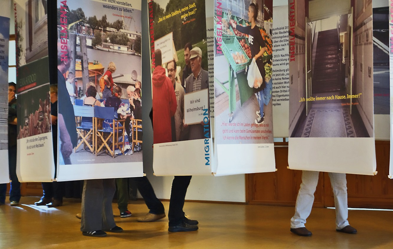 Besucherinnen und Besucher zwischen den Ausstellungsplakaten